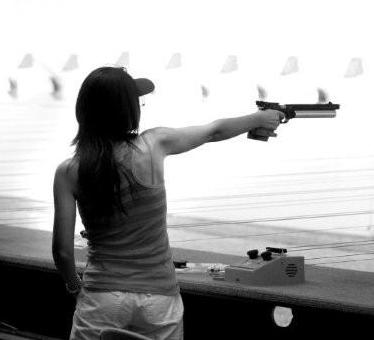 Woman competitor shooting air pistol at MISC